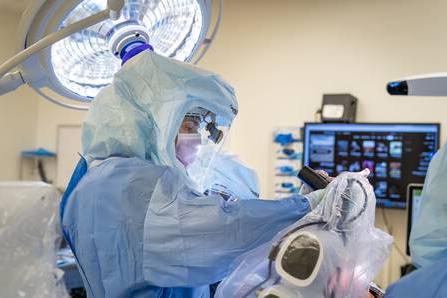 外科医生Wayne Moschetti正在使用一种新的机器人辅助手术工具.